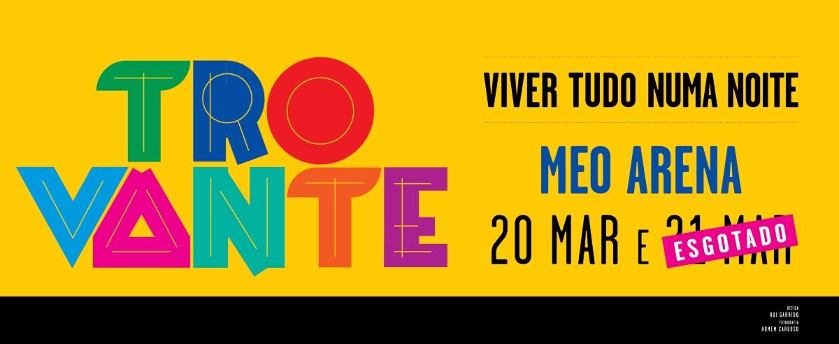 Imagem de cartaz do concerto "Trovante - Viver Tudo Numa Noite" com os membros da banda em pose em fundo amarelo.